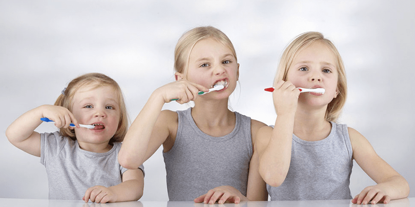 Three Children Brushing their teeth
