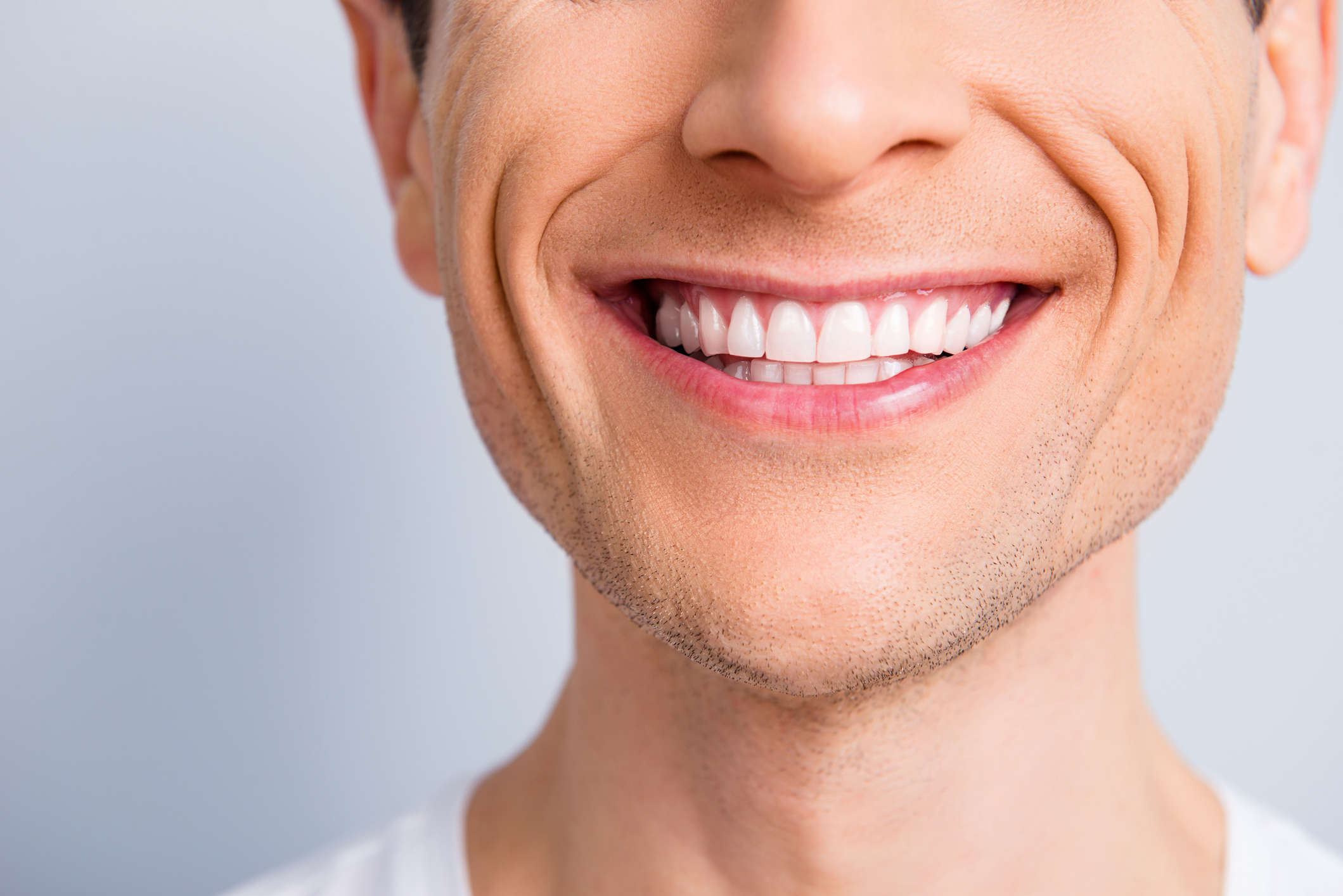 Close up cropped half face portrait of attractive, trendy, stylish, experienced, brunet, toothy man with wide beaming smile and healthy teeth